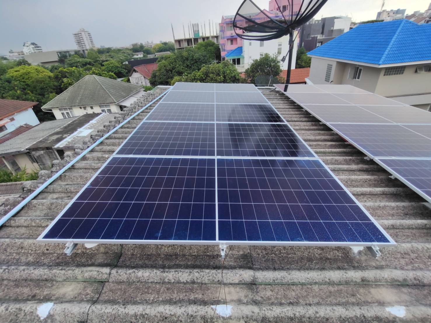 Array of solar panels with mounting brackets and installation hardware on residential rooftop